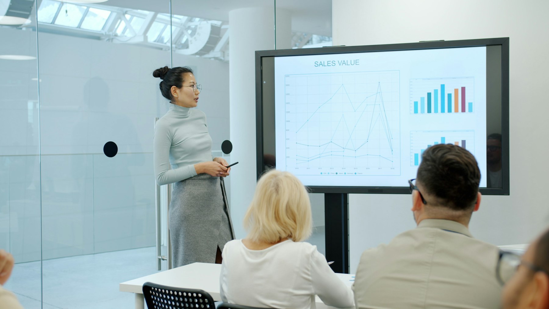 A presenter walking leadership through a chart on a screen in a briefing.