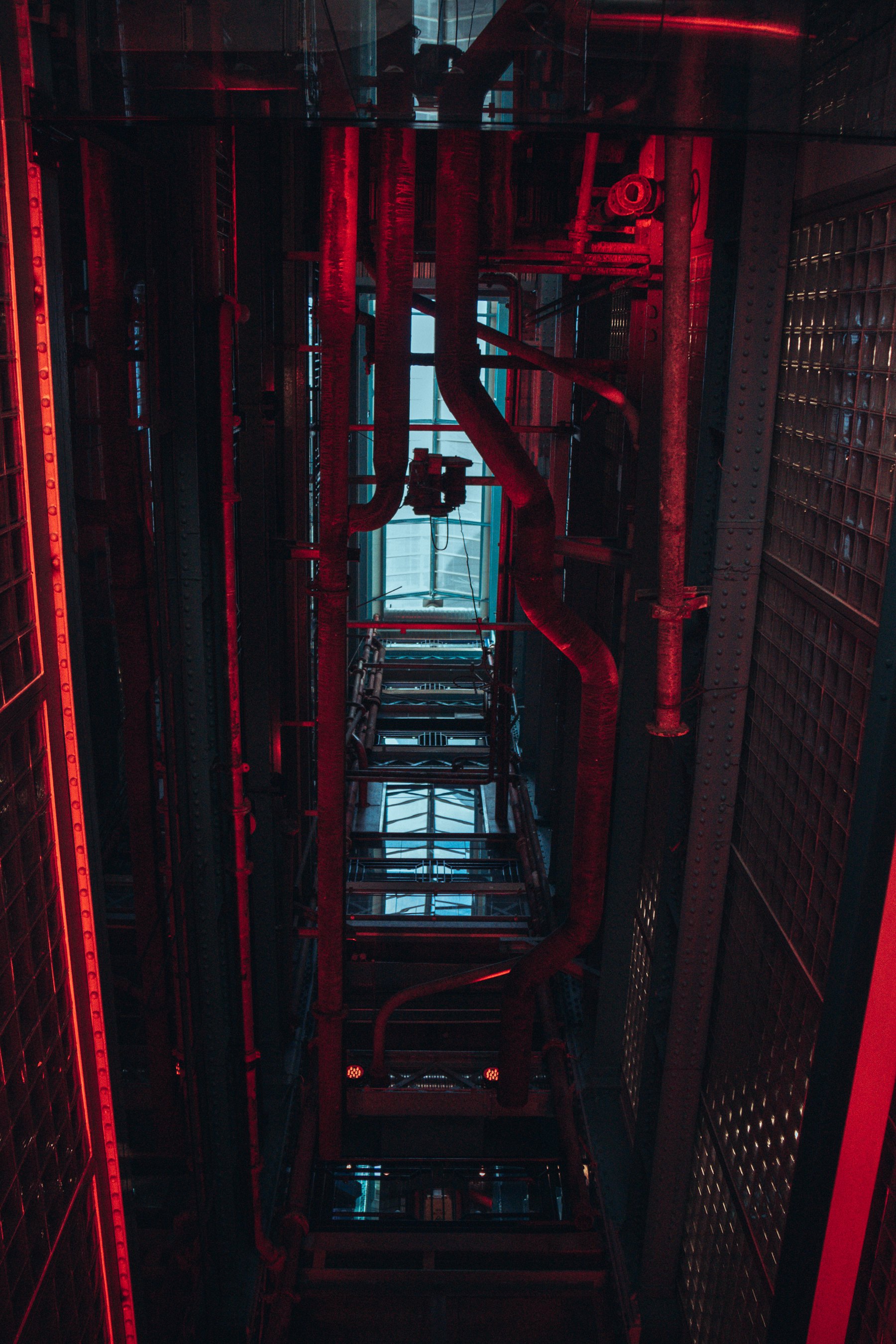 An industrial server infrastructure shaft lit in warning red.