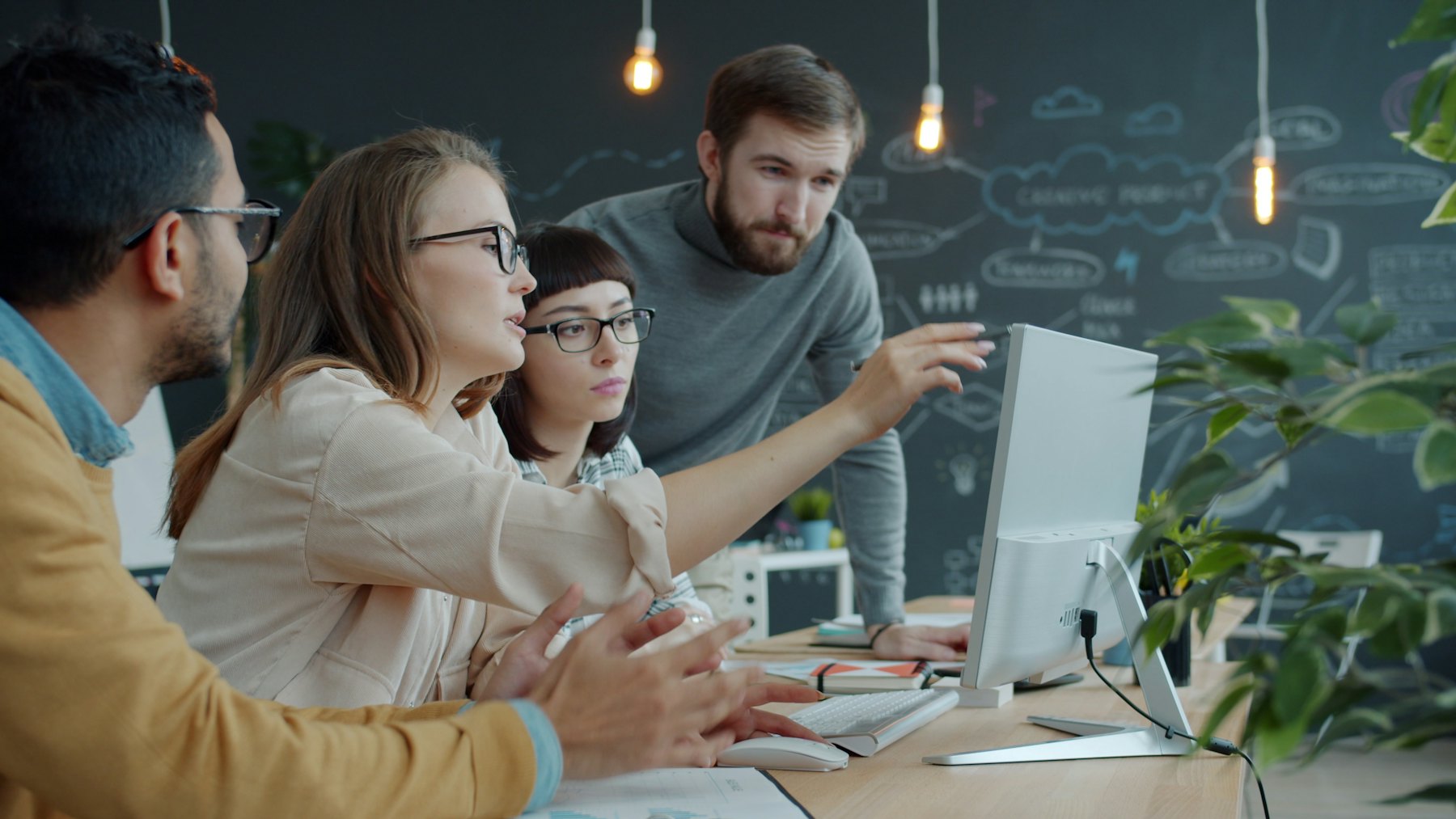 A SinuousTech team reviewing a system design together at a whiteboard.