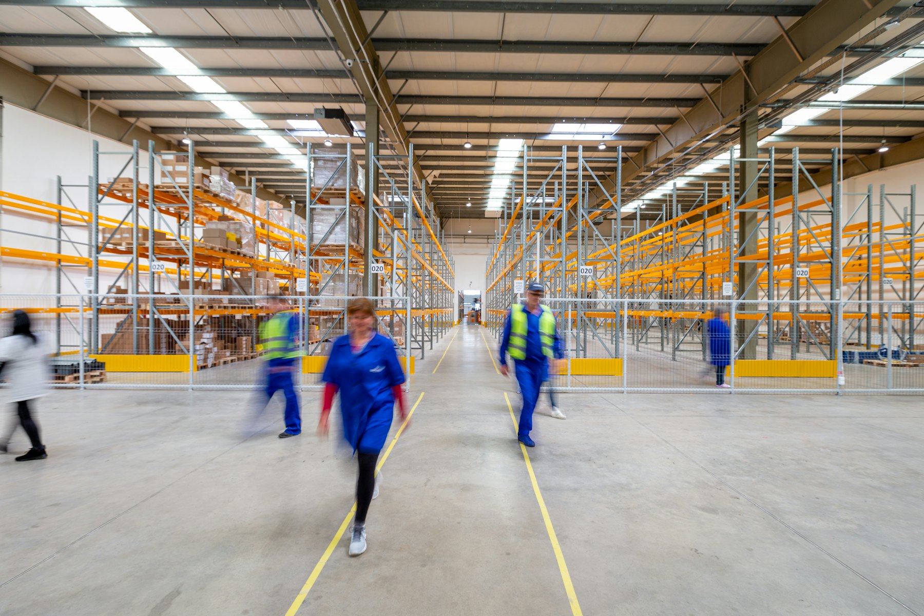 Warehouse staff walking through a modern distribution aisle.